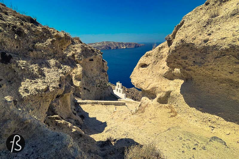 After a few minutes going down the hill, the bell tower of Agios Nikolaos started to appear, like it was being born out of the rocks. Together with the rocky cliff, the chapel looks like scenery made for pictures. The white building that seems like it goes into the cliff, as a chapel built in a cave. The view from there is fantastic, and it was more than worth the unusual hiking route we took down the hill.