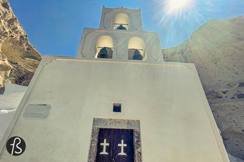 After a few minutes going down the hill, the bell tower of Agios Nikolaos started to appear, like it was being born out of the rocks. Together with the rocky cliff, the chapel looks like scenery made for pictures. The white building that seems like it goes into the cliff, as a chapel built in a cave. The view from there is fantastic, and it was more than worth the unusual hiking route we took down the hill.