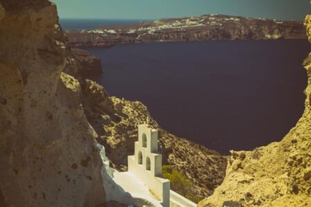 Agios Nikolaos is a small chapel in Megalochori, located on the island of Santorini. But this small church isn't like any other church, and it was built in the rocky cliffs that overlook the crater and the Aegean sea below. Its bell tower has the traditional triptych of bells that can be found all around the Greek islands, but this feels more unique due to its location.