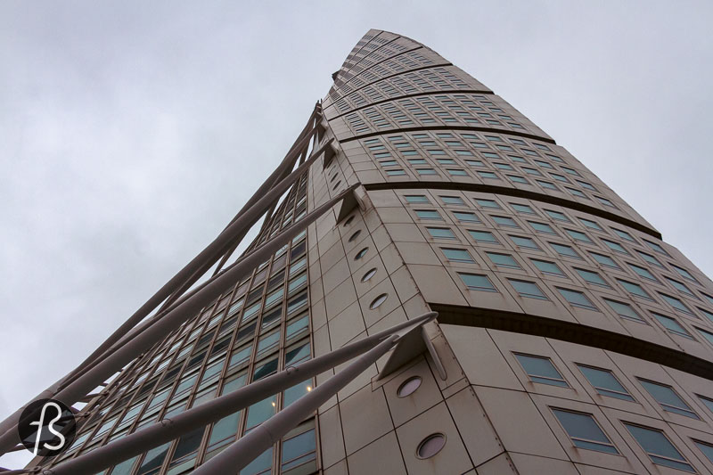 Looking up, you can see that the tower is made of nine cubed-shaped pieces staked on each other as they twist. Each of these cubes is five floors tall, and each floor is rotated by 1.6º degrees from the one below. With this rotation, going from the bottom to the top, the twist amounts to 90º, which gives the impression that the Turning Torso is rotating on its own axis. 