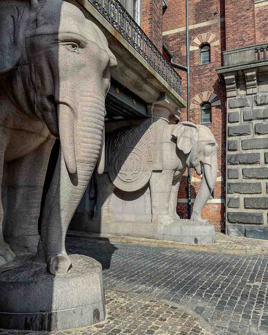 I went to visit the Elephant Gate at the old Carlsberg brewery site. This iconic landmark in town is a fascinating blend of history, architecture, and symbolism. The most notable feature is the four massive granite elephants that flank the gate, carrying the tower on their backs. And, if you pay attention to the pictures here, you might notice swastika symbols on the elephants’ blankets.