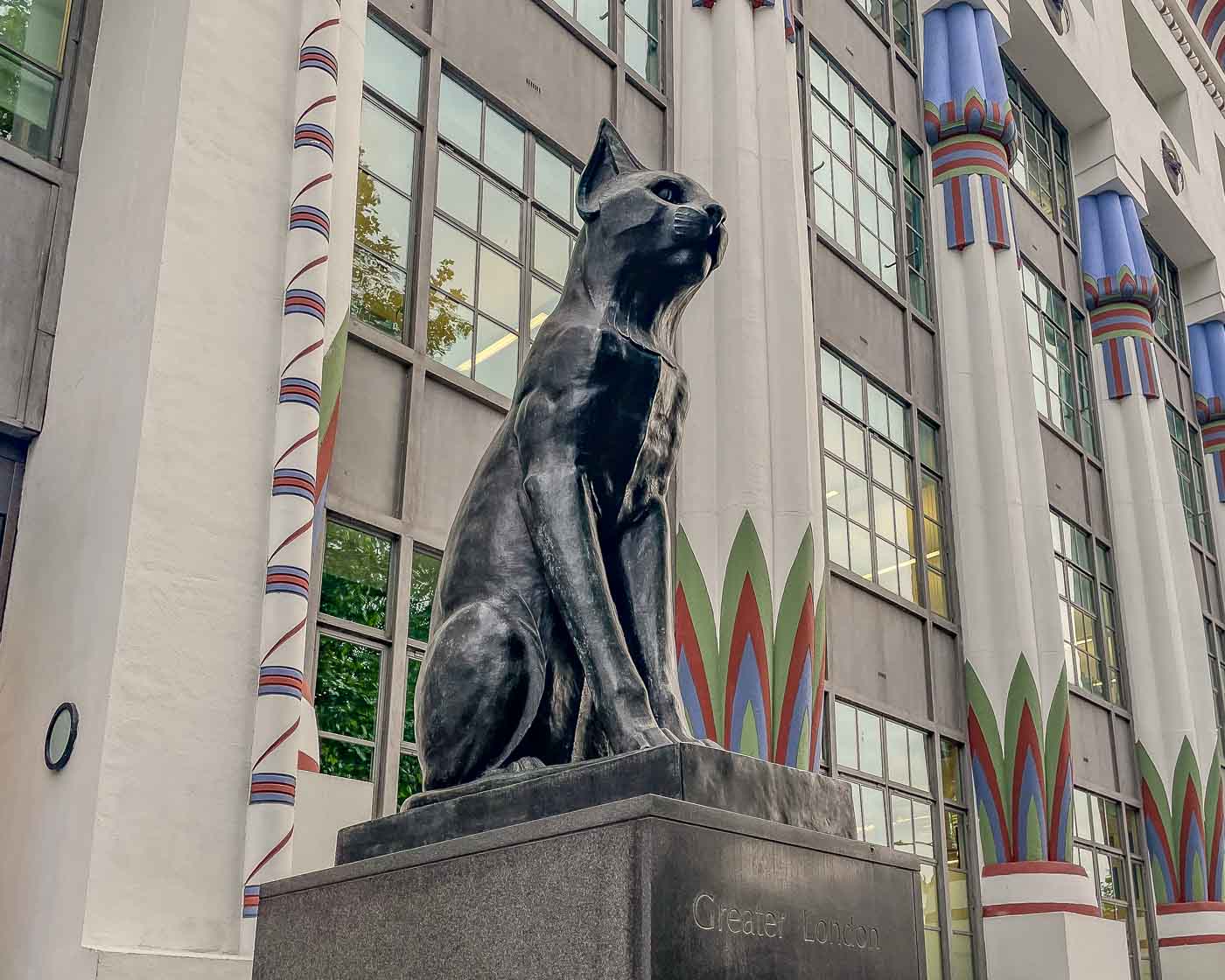 As you stroll through Camden Town, you might stumble upon a striking building adorned with black cat faces and guarded by two imposing cat statues. The former Carreras Cigarette Factory is a magnificent example of Egyptian Revival architecture.