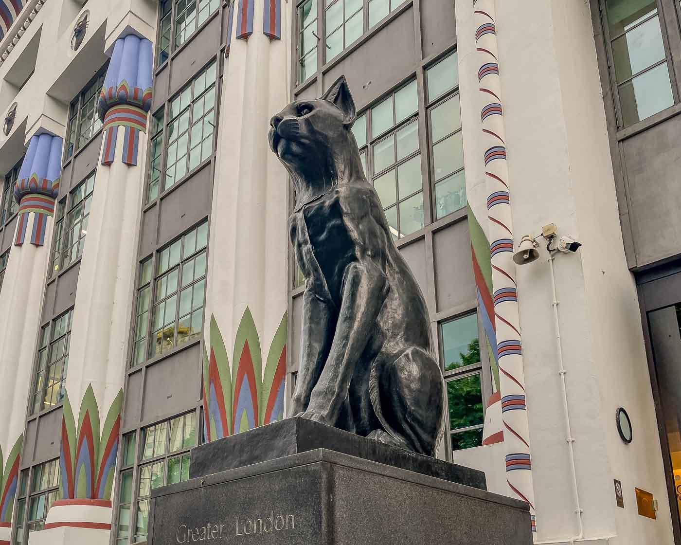 As you stroll through Camden Town, you might stumble upon a striking building adorned with black cat faces and guarded by two imposing cat statues. The former Carreras Cigarette Factory is a magnificent example of Egyptian Revival architecture.