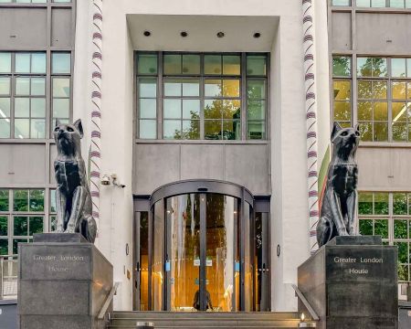 As you stroll through Camden Town, you might stumble upon a striking building adorned with black cat faces and guarded by two imposing cat statues. The former Carreras Cigarette Factory is a magnificent example of Egyptian Revival architecture.