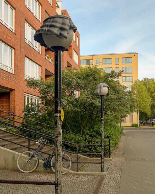 On the border of Mitte and Wedding lies Brunnenviertel, a neighborhood renowned for its inviting green spaces and tranquil, pedestrian-friendly courtyards. As dusk settles, a soft, romantic glow emanates from the area's distinctive spherical streetlamps. But there's a clever twist to that. Look closely, and you'll discover that many of these lamps are wearing hats. These are the Nightcaps, a brilliant public art installation that is both functional and fantastical.