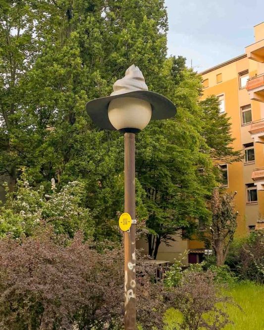 On the border of Mitte and Wedding lies Brunnenviertel, a neighborhood renowned for its inviting green spaces and tranquil, pedestrian-friendly courtyards. As dusk settles, a soft, romantic glow emanates from the area's distinctive spherical streetlamps. But there's a clever twist to that. Look closely, and you'll discover that many of these lamps are wearing hats. These are the Nightcaps, a brilliant public art installation that is both functional and fantastical.